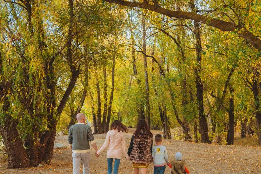 Семья на прогулке в парке осенью